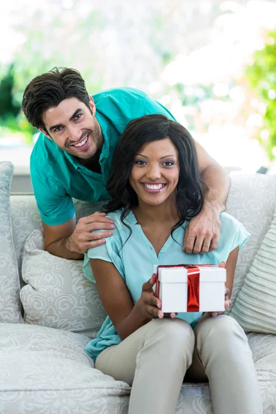 Mann und Frau auf Sofa mit Geschenk — Stockfoto