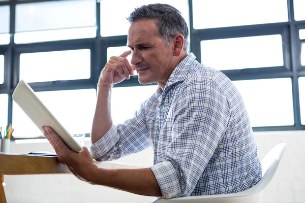 Thoughtful man looking at tablet — Stock Photo, Image
