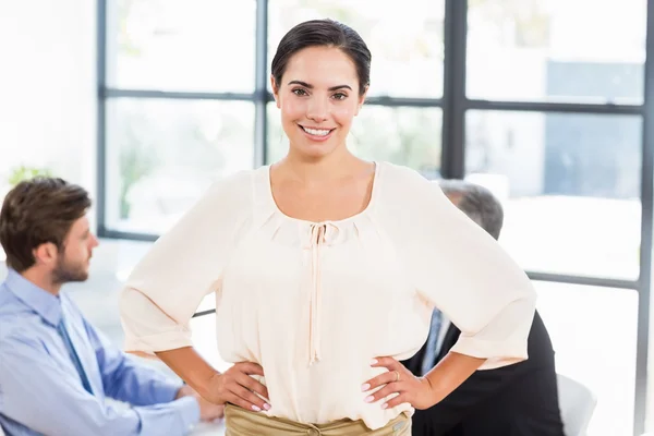 Geschäftsfrau lächelt mit den Händen auf den Hüften — Stockfoto