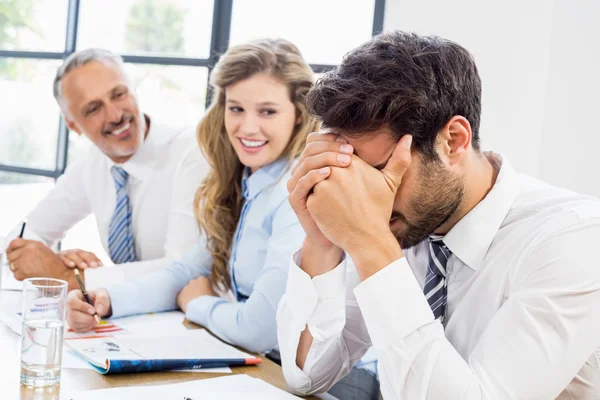 Colegas mirando frustrado hombre de negocios — Foto de Stock