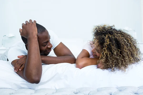 Couple lying on bed and talking — Stock Photo, Image