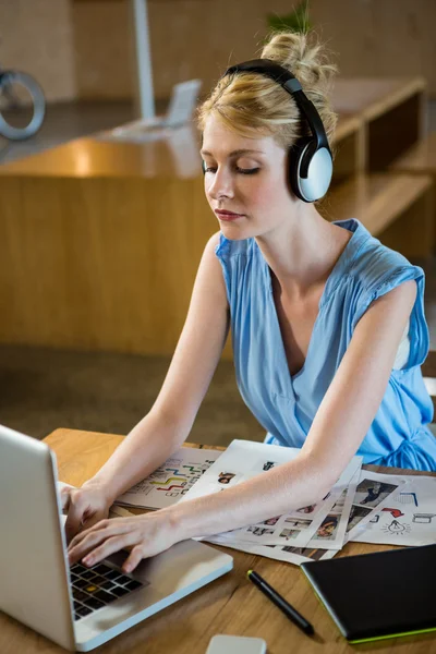 Graphic designer listening to headphones — Stock Photo, Image