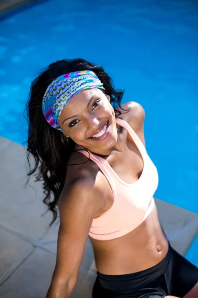 Mujer joven sentada junto a la piscina —  Fotos de Stock