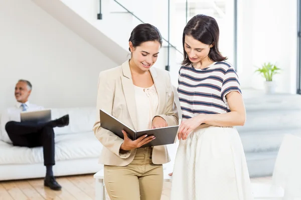 Businesswoman and colleague looking at diary — Stock Photo, Image