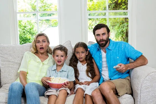 Familie lachen terwijl u tv kijkt — Stockfoto