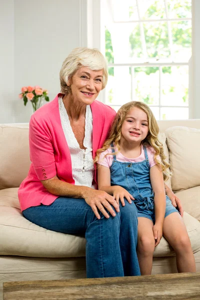 Farmor och flicka sitter på soffan — Stockfoto