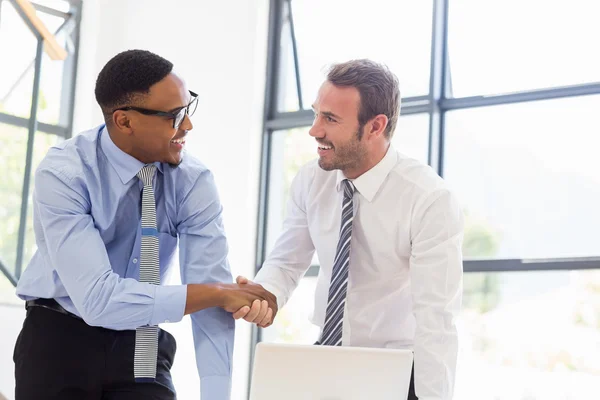 Businessmen shaking hands in office — Stock Photo, Image