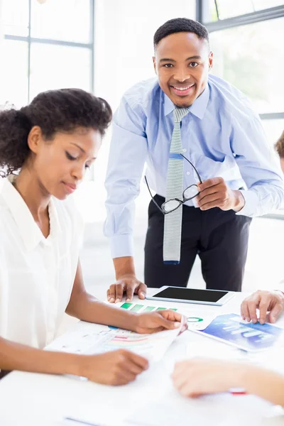 Ondernemers kijken naar rapporten in vergadering — Stockfoto