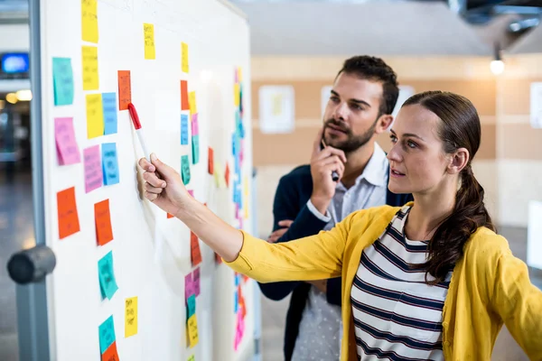 Kollegen schauen auf Whiteboard — Stockfoto