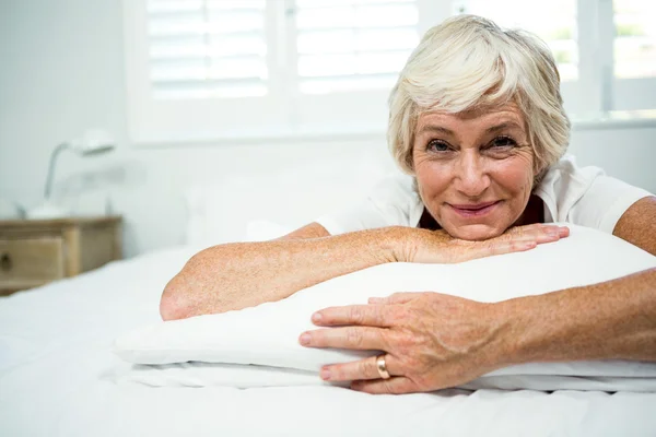 Lächelnde Frau entspannt sich auf dem Bett — Stockfoto