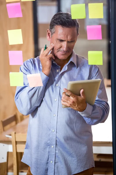 Nadenkende man kijken naar Tablet PC — Stockfoto