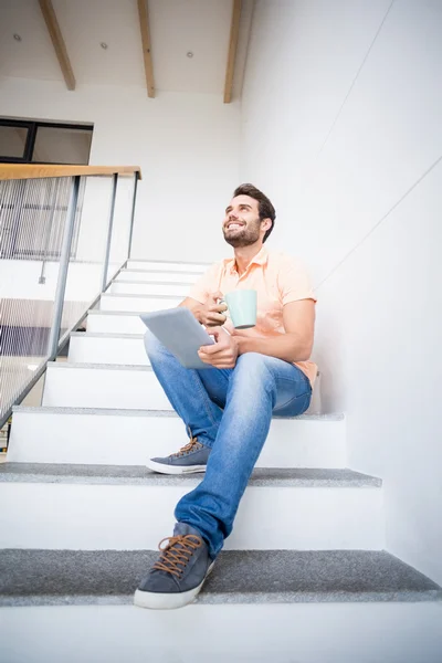 Man håller tablet och kaffekopp — Stockfoto