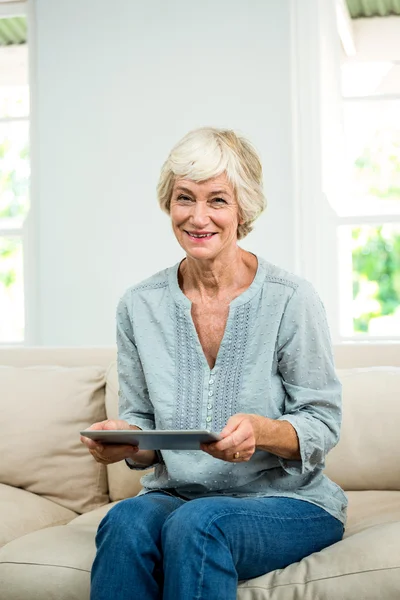 Lachende senior vrouw met tablet — Stockfoto