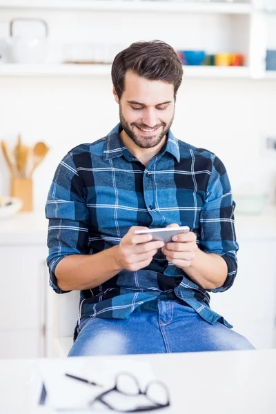 Hombre está sonriendo y mirando el teléfono inteligente — Foto de Stock