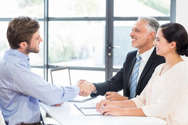 Businessmen shaking hands in office — Stock Photo, Image