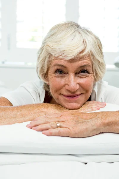 Lachende senior vrouw op bed — Stockfoto