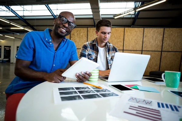 Colleagues using tablet and laptop — Stock Photo, Image