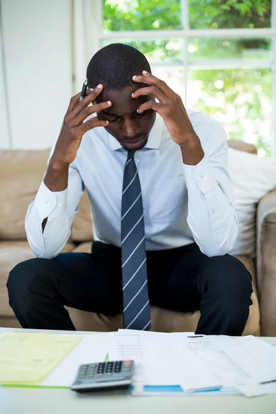 Spända man på soffan med räkningar — Stockfoto