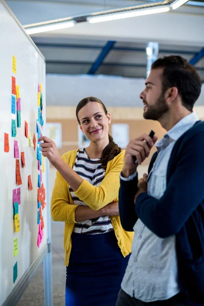 Kollegen schauen auf Whiteboard — Stockfoto