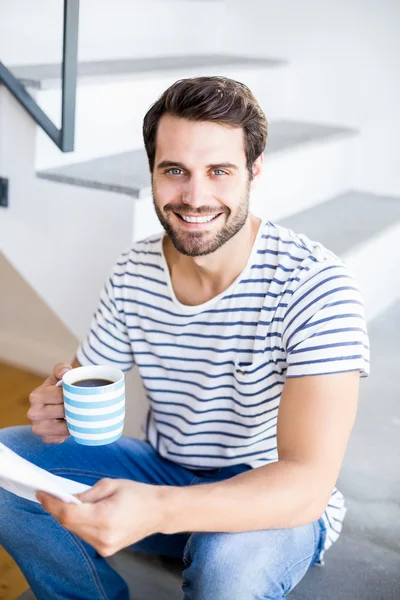 Man op stappen houden van koffie en het lezen — Stockfoto