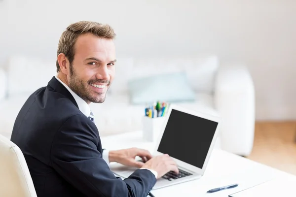 Affärsman med laptop på skrivbordet — Stockfoto