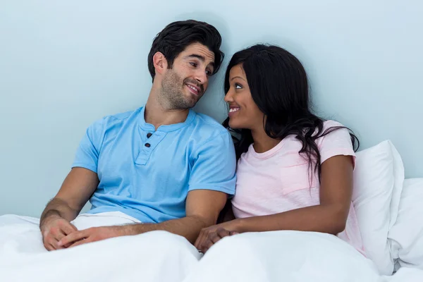 Junges Paar sitzt auf dem Bett — Stockfoto