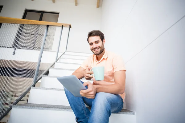 Man håller tablet och kaffekopp — Stockfoto