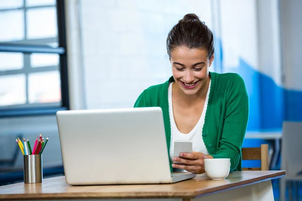 Woman using phone with laptop — Stock Photo, Image