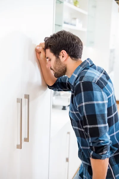 Depressieve man leunend hoofd tegen de deur — Stockfoto