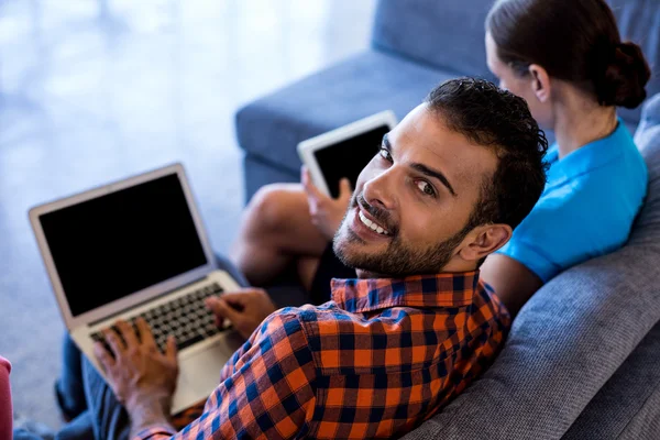 Colleagues siting on sofa using laptop — Stock Photo, Image