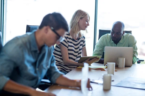 Colleagues interact at their desk — Stock Photo, Image