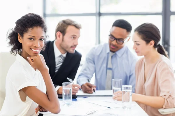 Businesswoman sitting with hand on chin — Stock Photo, Image