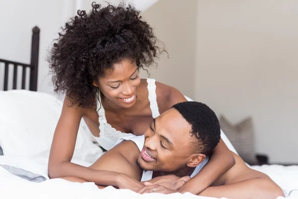 Casal deitado na cama e abraçando — Fotografia de Stock