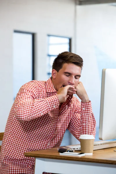 Man gäspar vid sitt skrivbord — Stockfoto