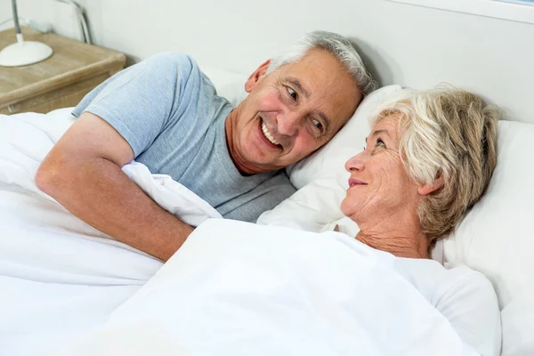Äldre par avkopplande på sängen — Stockfoto