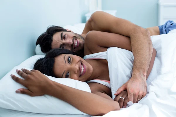 Couple embracing lying on bed — Stock Photo, Image