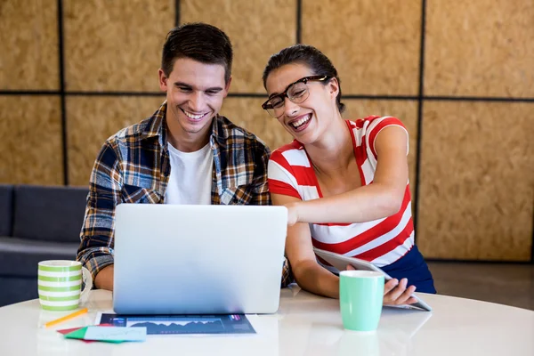 Colegas interagem usando laptop na mesa — Fotografia de Stock