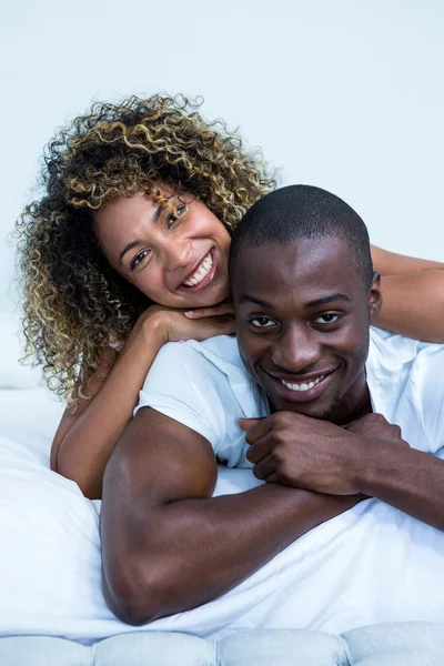 Young couple cuddling on bed — Stock Photo, Image