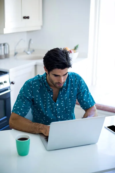 Man on table and using laptop — Stock Photo, Image