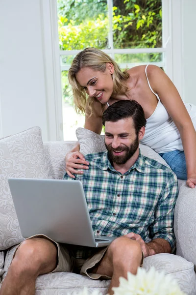 Casal usando laptop na sala de estar — Fotografia de Stock