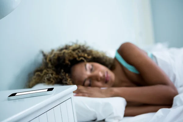 Mujer joven durmiendo en la cama — Foto de Stock