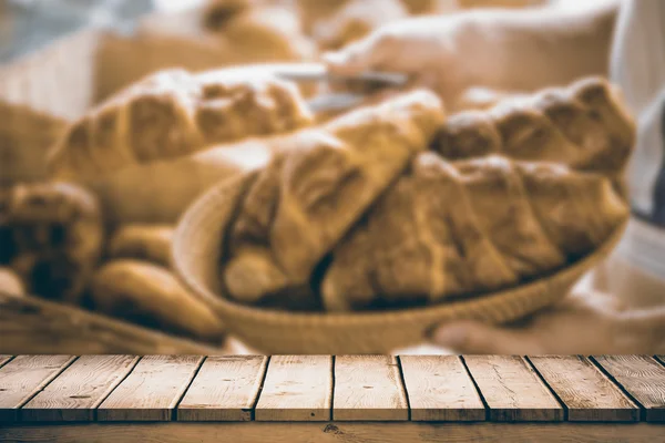 Worker holding basket of croissant — Stock Photo, Image