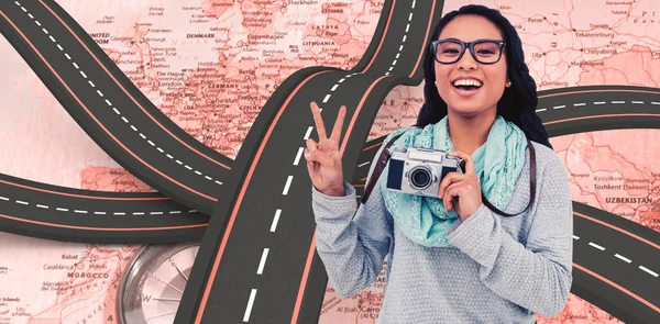 Donna che tiene la macchina fotografica e fa segno di pace — Foto Stock