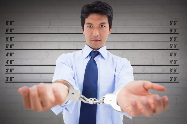businessman with handcuffs against height measurement