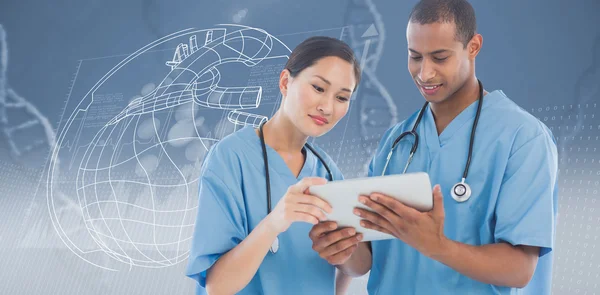 Хирурги смотрят на цифровой планшет в больнице — стоковое фото