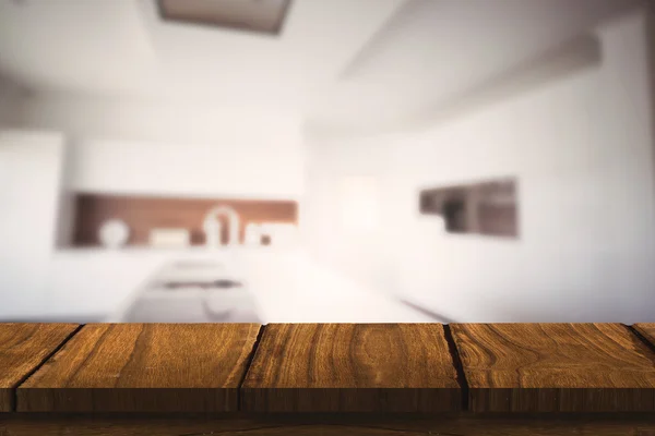 Dřevěný stůl proti moderní kuchyně — Stock fotografie