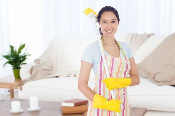 Lachende vrouw met een bezem op haar schouder — Stockfoto