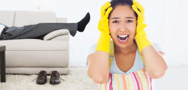 Mujer angustiada usando delantal y guantes de goma —  Fotos de Stock