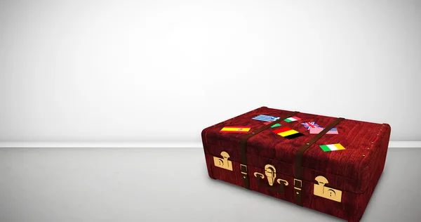 Suitcase with stickers against grey room — Stock Photo, Image