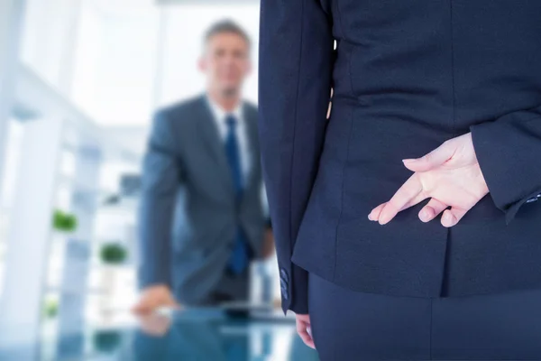 Businesswoman with fingers crossed behind back — Stock Photo, Image